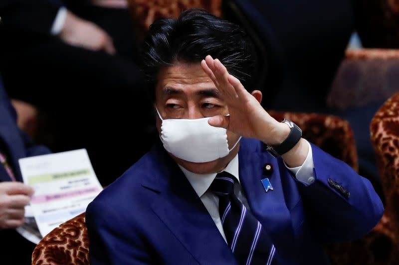 Japan's Prime Minister Shinzo Abe wears a protective face mask as he attends an upper house parliamentary session