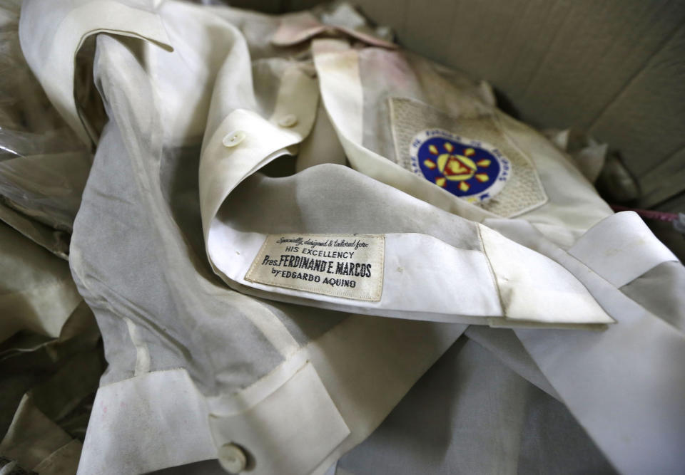 In this photo taken Sept. 19, 2012, native Filipino attire called "Barongs" which had been often worn in public during the two-decade rule of the late strongman Ferdinand Marcos, is revealed from a section of the National Museum in Manila, Philippines. Termites, storms and government neglect have damaged hundreds of pieces of Marcos' "barongs" as well as former first lady Imelda Marcos's legendary stash of shoes, expensive gowns and other vanity possessions, which were left to oblivion after she and her dictator husband were driven to U.S. exile by a 1986 popular revolt. (AP Photo/Bullit Marquez)