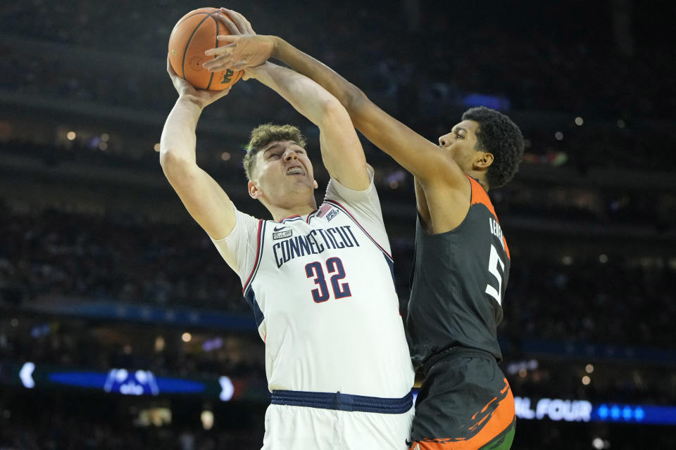 Connecticut center Donovan Clingan shoots the ball against Miami guard Harlond Beverly during the Final Four of the 2023 NCAA men's tournament at NRG Stadium in Houston on April 1, 2023. (Bob Donnan/USA TODAY Sports)