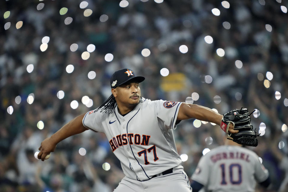 Fans hold up cell phone lights as Houston Astros relief pitcher Luis Garcia (77) warms up during the 15th inning in Game 3 of an American League Division Series baseball game against the Seattle Mariners, Saturday, Oct. 15, 2022, in Seattle. (AP Photo/Ted S. Warren)