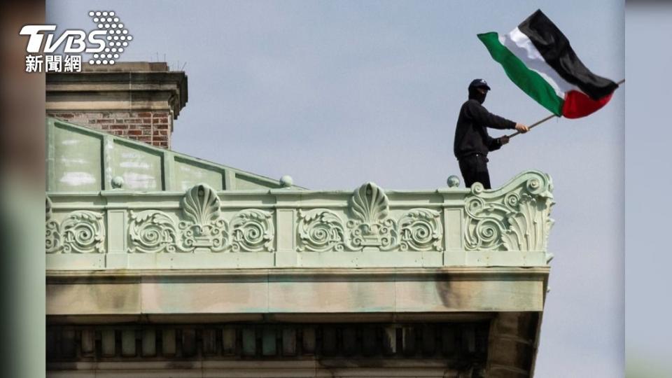 示威者爬上漢彌爾頓大樓（Hamilton Hall）頂部揮舞巴勒斯坦旗幟。（圖／達志影像路透社）