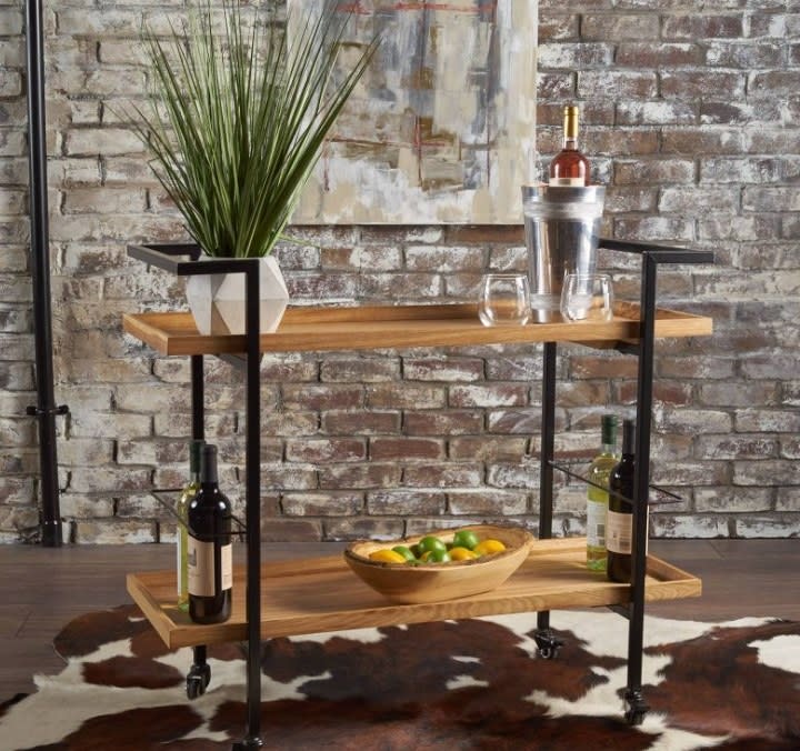 Wooden bar cart with brick wall in background
