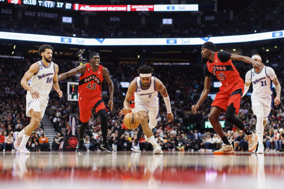 Washington Wizards guard Jordan Goodwin (7) controls the ball as he drives to the net against Toronto Raptors forward Chris Boucher (25) during the first half of an NBA basketball game in Toronto, Sunday, March 26, 2023. (Cole Burston/The Canadian Press via AP)