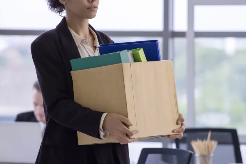 Person walking out of the office with a cardboard box.