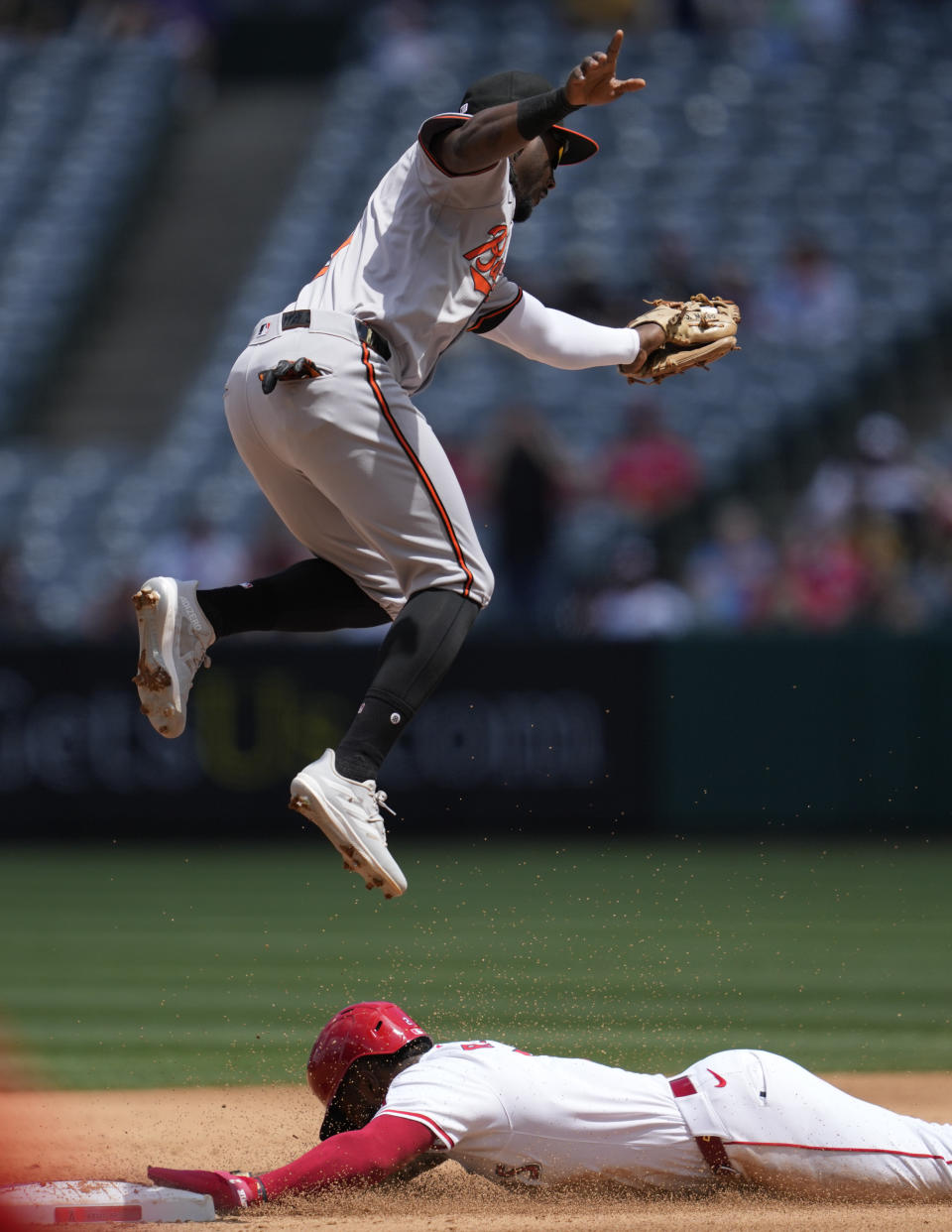 Los Angeles Angels' Luis Rengifo, bottom, steals second ahead of a throw to Baltimore Orioles second baseman Jorge Mateo during the third inning of a baseball game in Anaheim, Calif., Wednesday, April 24, 2024. (AP Photo/Ashley Landis)