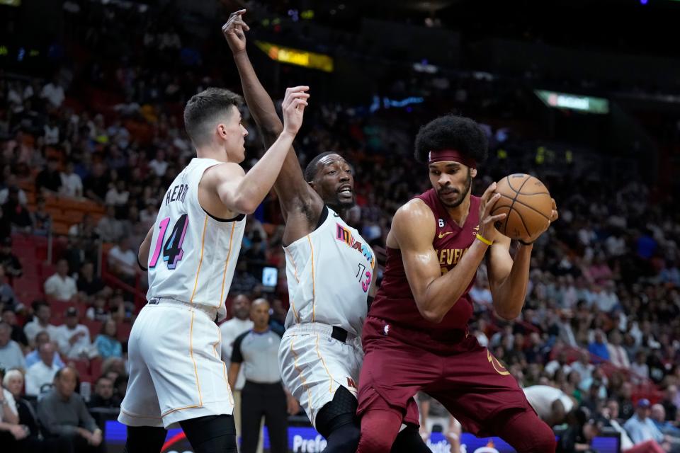 Cleveland Cavaliers center Jarrett Allen, right, goes up for a shot against Miami Heat guard Tyler Herro (14) and center Bam Adebayo during the first half of an NBA basketball game, Wednesday, March 8, 2023, in Miami. (AP Photo/Wilfredo Lee)