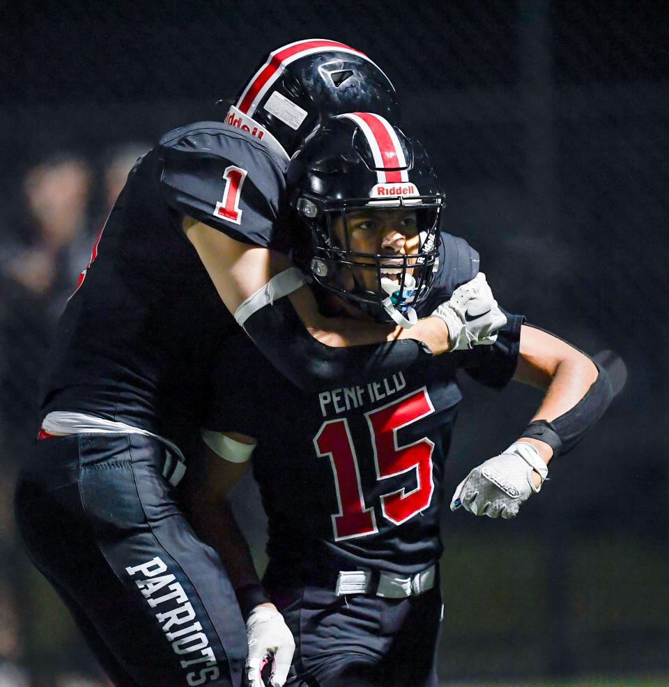 Penfield's Elijah Sanchez (15) celebrates with Nicholas Masters after returning the second half kickoff for a touchdown during a regular season game against Fairport, Friday, Sept. 1, 2023.