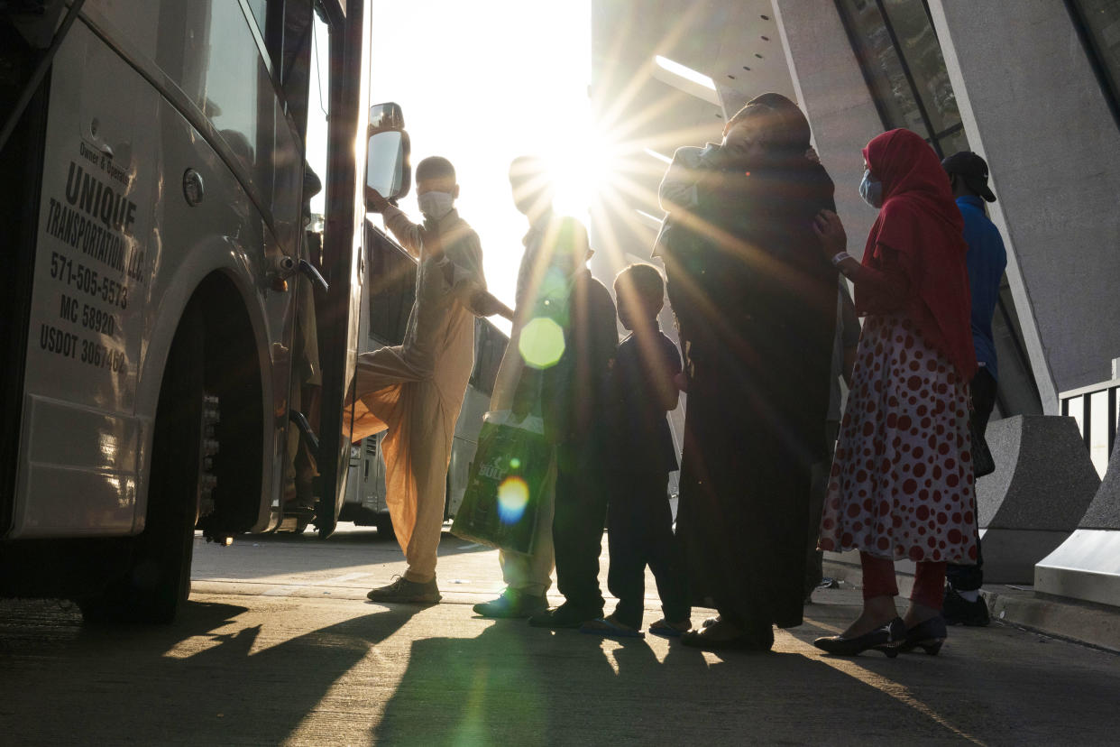 Families evacuated from Kabul, Afghanistan, wait to board a bus after they arrived at Washington Dulles International Airport, in Chantilly, Va., on Friday, Aug. 27, 2021. In late summer 2021, the Taliban seized power in Afghanistan. (Jose Luis Magana/AP)