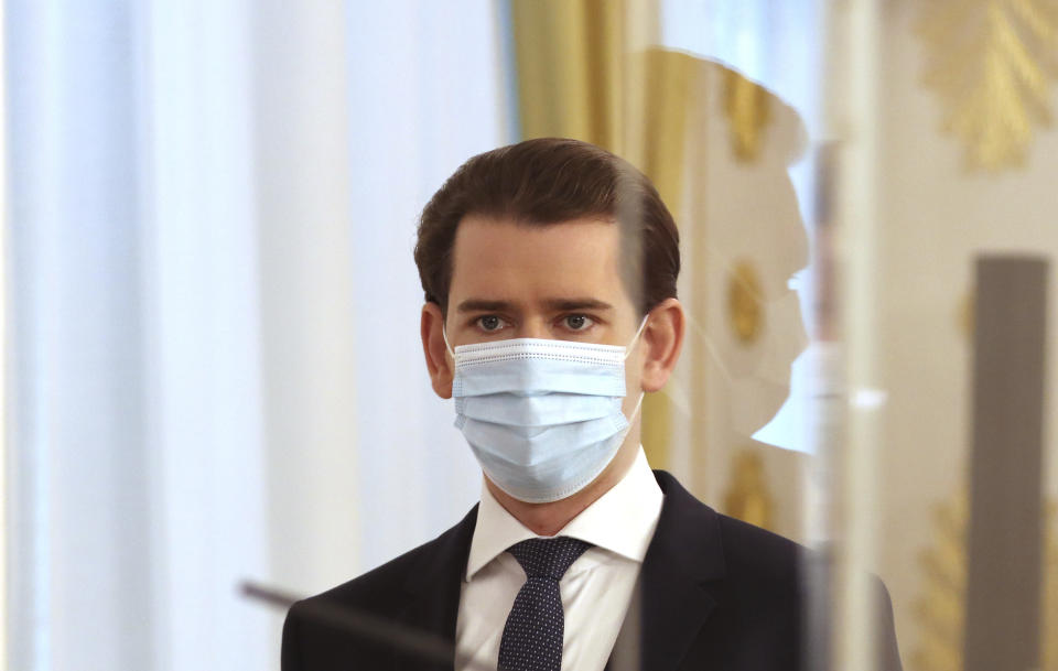 Austrian Chancellor Sebastian Kurz wears a face mask as he arrives behind plexiglass shields for a press conference at the federal chancellery in Vienna, Austria, Wednesday, Dec. 2, 2020. The Austrian government has moved to restrict freedom of movement for people, in an effort to slow the onset of the COVID-19 coronavirus. (AP Photo/Ronald Zak)