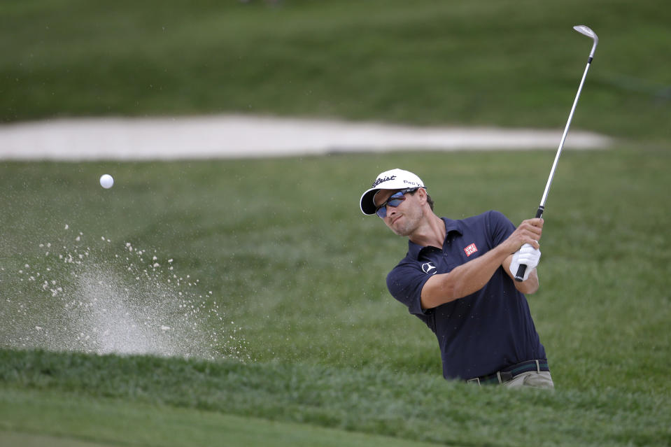 Adam Scott, of Australia, hits out of a bunker onto the 18th green during the first round of the Honda Classic golf tournament on Thursday, Feb. 27, 2014, in Palm Beach Gardens, Fla. (AP Photo/Lynne Sladky)
