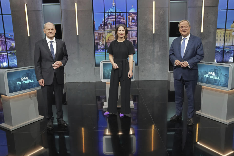 Olaf Scholz, candidate for chancellor of the SPD and Federal Minister of Finance, left, Annalena Baerbock, German Green Party co-leader and candidate for chancellor, center, and Armin Laschet, candidate for chancellor of the CDU/CSU and chairman of the CDU, right, stand together before the start of the third TV debate in Berlin, Sunday Sept. 19, 2021. (Kay Nietfeld/dpa via AP)