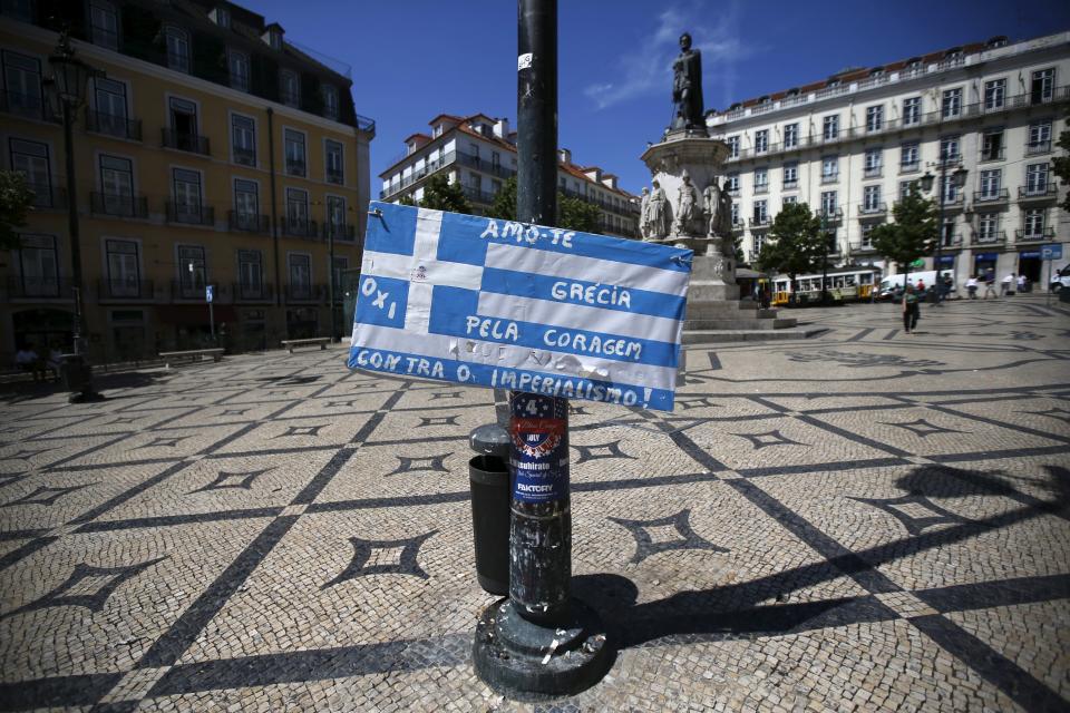 A Greek flag with a message on it is seen in Camoes square in Lisbon