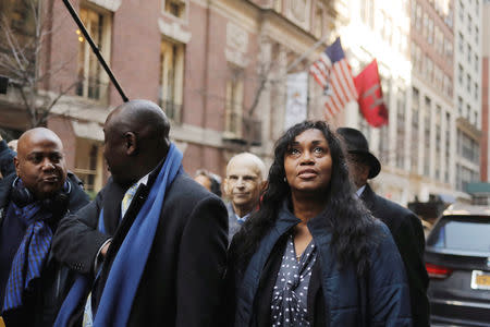 Tamara Lanier looks up as she walks with attorney Ben Crump (C) after speaking to the media about a lawsuit accusing Harvard University of the monetization of photographic images of her great-great-great grandfather, an enslaved African man named Renty, and his daughter, Delia outside of the Harvard Club in New York, U.S., March 20, 2019. REUTERS/Lucas Jackson