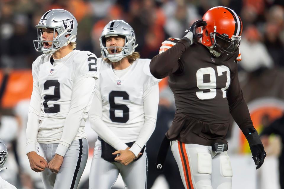 Las Vegas Raiders kicker Daniel Carlson (2) and holder A.J. Cole (6) celebrate after Carlson kicked the game-winning field goal as Browns defensive tackle Malik Jackson (97) walks off the field during the fourth quarter in Cleveland, Dec. 20, 2021.