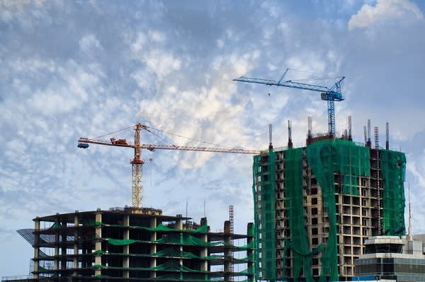 15467457 - building crane and building under construction against blue sky