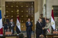 French Prime Minister Manuel Valls (L) and Egyptian President Abdel Fattah al-Sisi (C) applaud as French Defence Minister Jean-Yves Le Drian (2R) shakes hands with his Egyptian counterpart General Sedki Sobhi (R) after signing military contracts