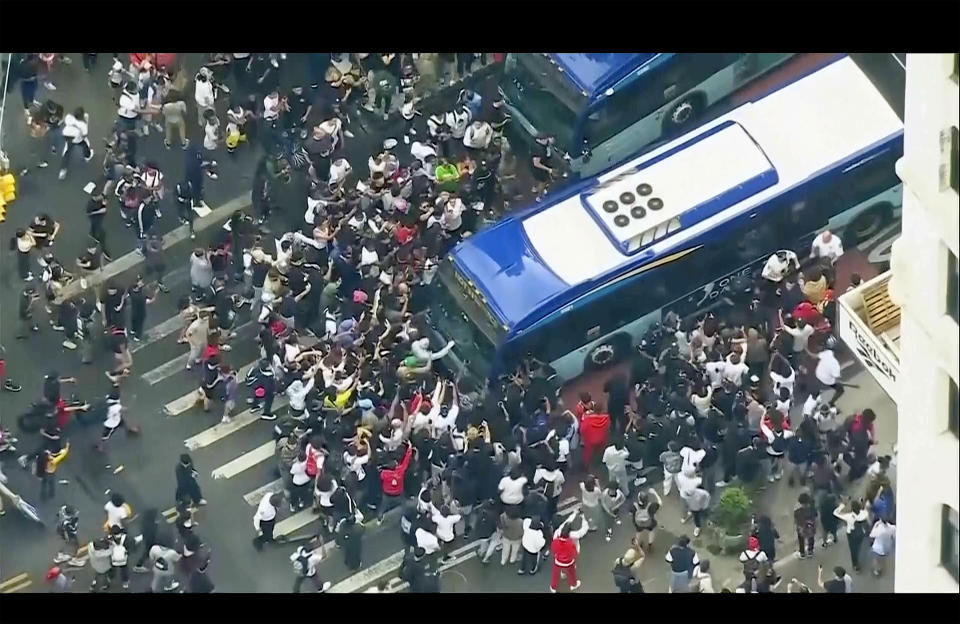 En esta imagen, tomada de un video proporcionado por la televisora WABC-TV, una multitud impide el paso de un autobús del transporte público que intenta avanzar a través de Union Square, el viernes 4 de agosto de 2023, en Nueva York. (WABC-TV vía AP)