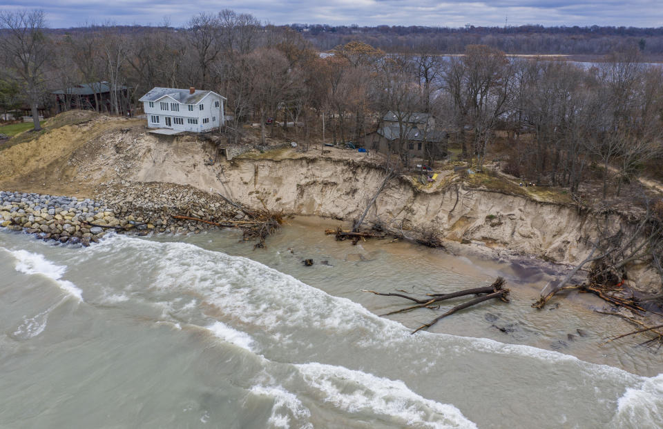 FILE - In this Dec. 4, 2019 file photo, erosion reaches a house along Lake Michigan's southwestern shoreline in Stevensville, Mich. A months-long spell of dry, mild weather is giving the Great Lakes a break after two years of high water that shattered records and heavily damaged shoreline roads and homes, officials said Monday May 10, 2021. (Robert Franklin/South Bend Tribune via AP. file)