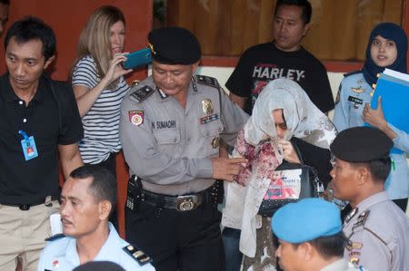 Australian drug convict Schapelle Corby (R) is escorted by police after reporting to a parole office before her expected deportation to Australia, in Denpasar, Bali, Indonesia May 27, 2017 in this photo taken by Antara Foto. Antara Foto/Nyoman Budhiana/via REUTERS