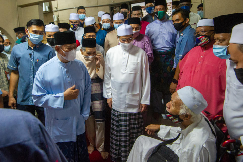 Prime Minister Tan Sri Muhyiddin speaks to a mosque congregant at Masjid Jamek Al-Amaniah, Batu Caves, April 19, 2021. With him is Gombak Member of Parliament Datuk Seri Mohamed Azmin Ali. — Picture by Shafwan Zaidon