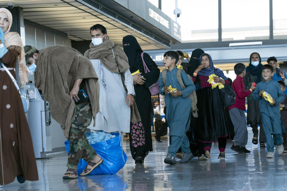 People evacuated from Kabul, Afghanistan, walk through the terminal before boarding a bus after they arrived at Washington Dulles International Airport, in Chantilly, Va., on Thursday, Sept. 2, 2021. (AP Photo/Jose Luis Magana)