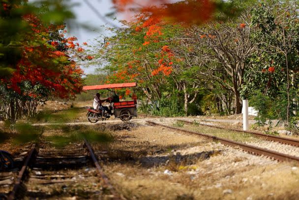 PHOTO: A man on a motorcycle crosses the old train tracks where section 3 of the new Mayan Train route was planned to be built before protests moved construction to the outskirts of the city, in Chochola, Yucatan, Mexico, May 16, 2022. (Jose Luis Gonzalez/Reuters)