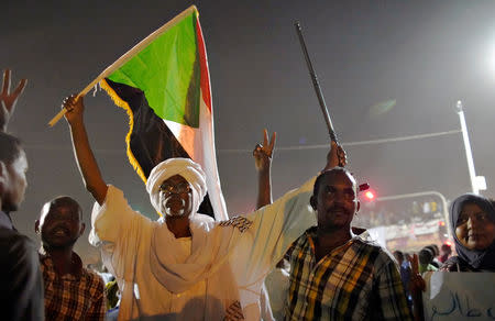 Demonstrators wave their national flag as they attend a protest rally demanding Sudanese President Omar Al-Bashir to step down outside Defence Ministry in Khartoum, Sudan April 10, 2019. REUTERS/Stringer