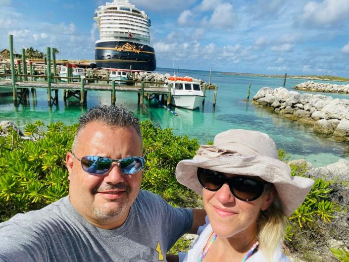 Greg and Elyssa Antonelle in front of a Disney cruise ship.