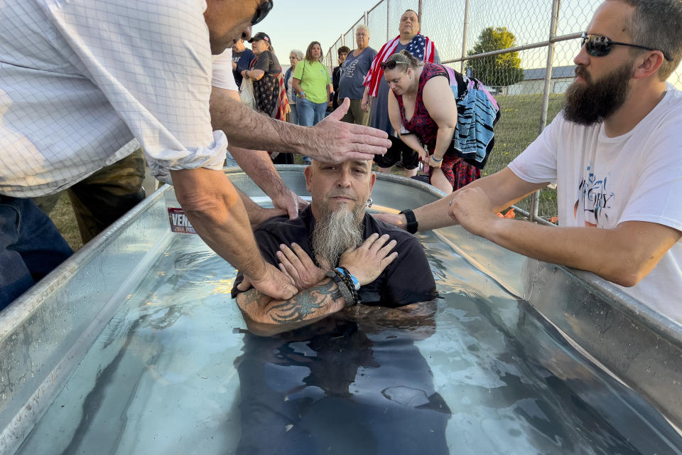 A man is baptized during the ReAwaken America tour at Cornerstone Church, in Batavia, N.Y., Friday, Aug. 12, 2022. Speaking at the event, Michael Flynn, former national security adviser to former President Donald Trump, is trying to build a movement centered on Christian nationalist ideas, where Christianity is at the center of American life and institutions. (AP Photo/Carolyn Kaster)