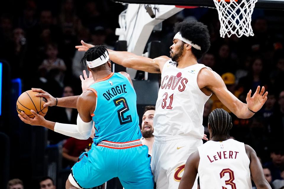 Phoenix Suns' Josh Okogie (2) gets double-teamed by Cleveland Cavaliers' Kevin Love, middle, and Jarrett Allen (31) during the first half of an NBA basketball game in Phoenix, Sunday, Jan. 8, 2023. (AP Photo/Darryl Webb)