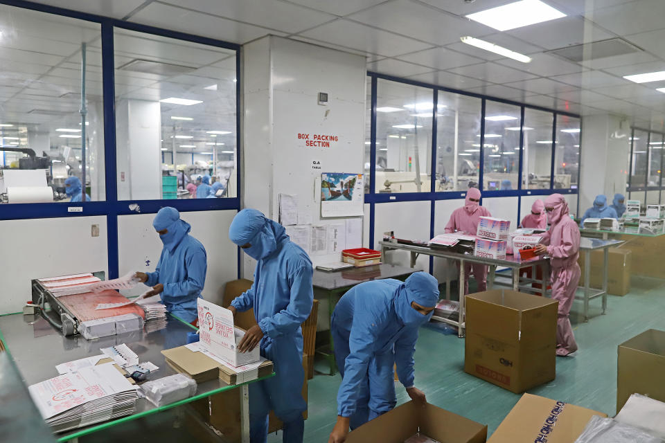 Employees pack boxes of syringes on the production line at the Hindustan Syringes and Medical Devices Ltd. facility in Faridabad, Haryana, on March 11.<span class="copyright">Anindito Mukherjee—Bloomberg/Getty Images</span>
