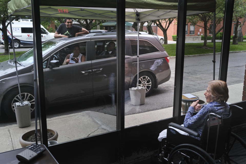 Gloria DeSoto, 92, visits with her family in their car through a window of the Hebrew Home at Riverdale in Bronx, N.Y., on June 11. (Seth Wenig / AP file)