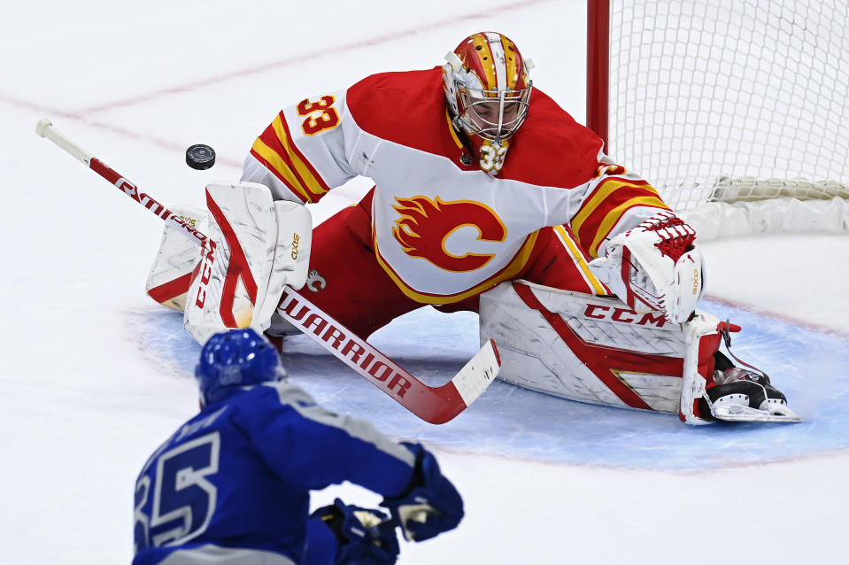 Calgary Flames goaltender David Rittich (33) makes a save on Toronto Maple Leafs right wing Ilya Mikheyev (65) during second period NHL hockey action in Toronto on Wednesday, Feb. 24, 2021. (Frank Gunn/The Canadian Press via AP)