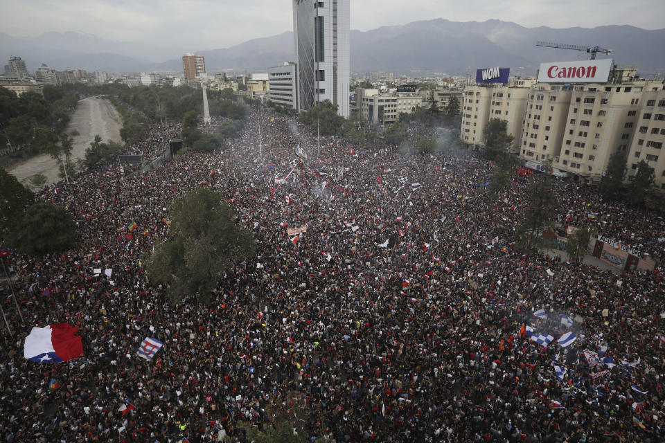 FILE - In this Oct. 25, 2019 file photo, people gather during an anti-government protest in Santiago, Chile. At least 19 people have died in the turmoil that has swept the South American nation. The unrest began as a protest over a 4-cent increase in subway fares and soon morphed into a larger movement over growing inequality in one of Latin America's wealthiest countries. (AP Photo/Rodrigo Abd, File)