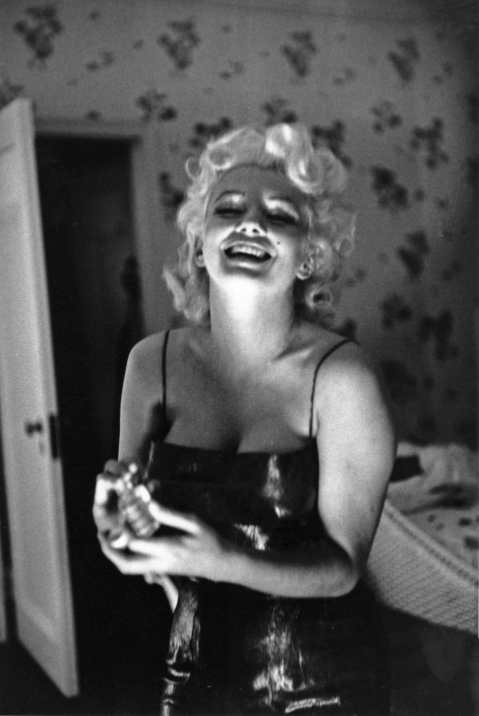 Marilyn Monroe applying Chanel No. 5 in 1955 at the Ambassador Hotel in New York City. (Photo: Getty Images)