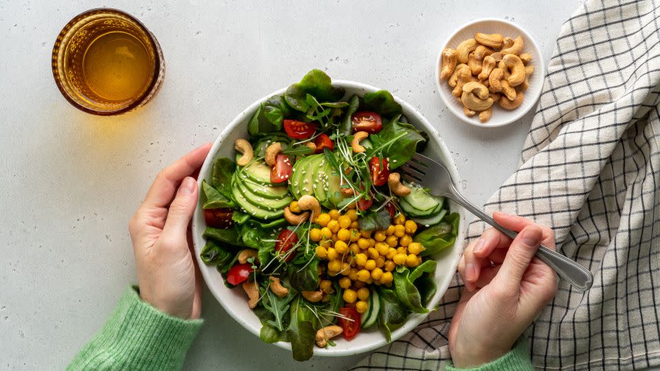 Eating a plant-based diet such as a salad with avocados, micro-greens, chickpeas, tomatoes, lettuce and cucumbers can help to rein in the climate crisis. - Natalia Gdovskaia/Moment RF/Getty Images