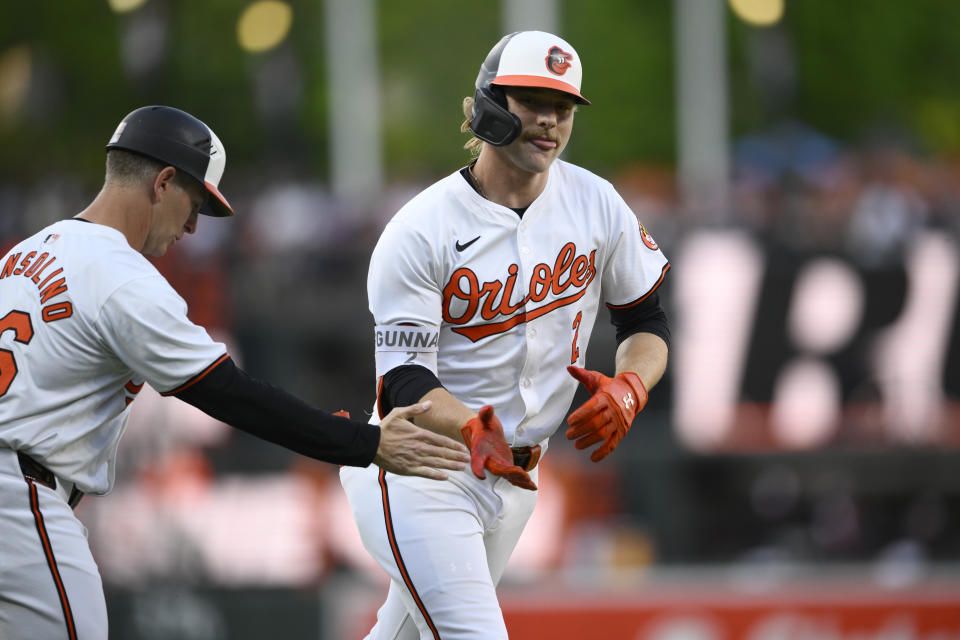 Baltimore Orioles' Gunnar Henderson, right, celebrates after his home run with third base coach Tony Mansolino, left, during the first inning of a baseball game against the New York Yankees, Monday, April 29, 2024, in Baltimore. (AP Photo/Nick Wass)