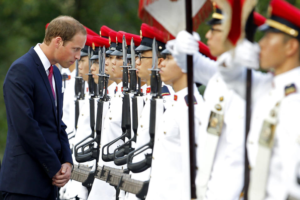 Prince William, the Duke of Cambridge, left, stops to talk to an honor guard member during the welcome ceremony at the Istana, or Presidential Palace, on Tuesday Sept. 11, 2012 in Singapore. The Duke and Duchess of Cambridge started an official three-day trip to Singapore Tuesday. (AP Photo/Wong Maye-E)