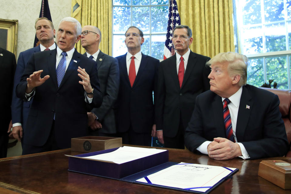 President Donald Trump listens to Vice President Mike Pence following a ceremony signing the "America's Water Infrastructure Act of 2018" into law in the Oval Office at the White House in Washington, Tuesday, Oct. 23, 2018. (AP Photo/Manuel Balce Ceneta)