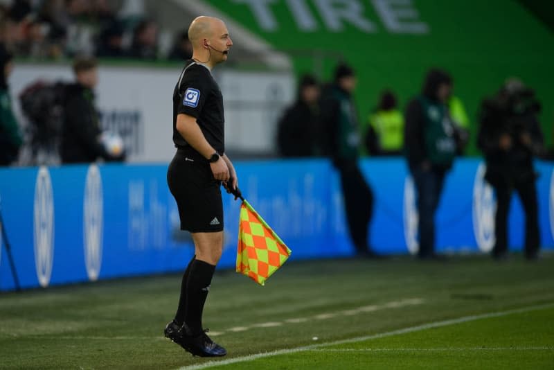 Fourth official Nicolas Winter takes over from assistant referee Thorben Siewer after an injury during the German Bundesliga soccer match between VfL Wolfsburg and FC Cologne at Volkswagen Arena. Swen Pförtner/dpa