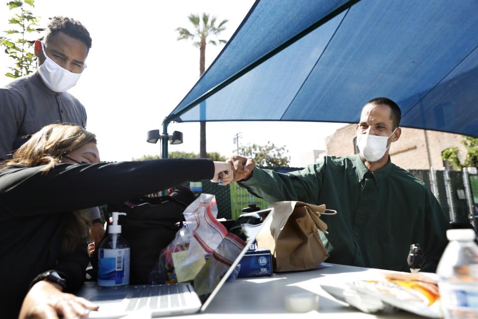 Damion Corral, 45, right, gets fist bumps, affirmations and Target gift cards from a team from LAC + USC Medical Center.