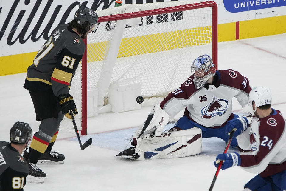 Colorado Avalanche goaltender Philipp Grubauer (31) makes a save as Vegas Golden Knights right wing Mark Stone (61) watches during the first period of an NHL hockey game Monday, May 10, 2021, in Las Vegas. (AP Photo/John Locher)