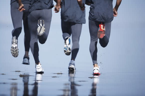 Joggers running on the beach.