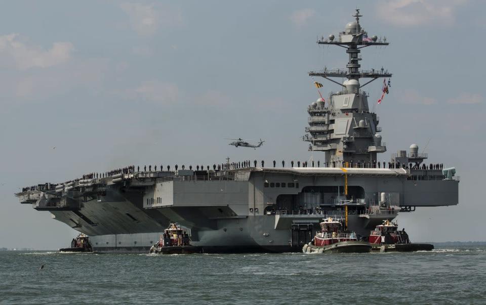 Dans cette photo d'archive du 14 avril 2017, alors que les membres d'équipage se tiennent sur le pont, le porte-avions USS Gerald R. Ford se dirige vers la station navale de Norfolk, en Virginie (AP)