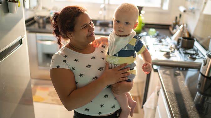 Babysitter and baby boy at kitchen.