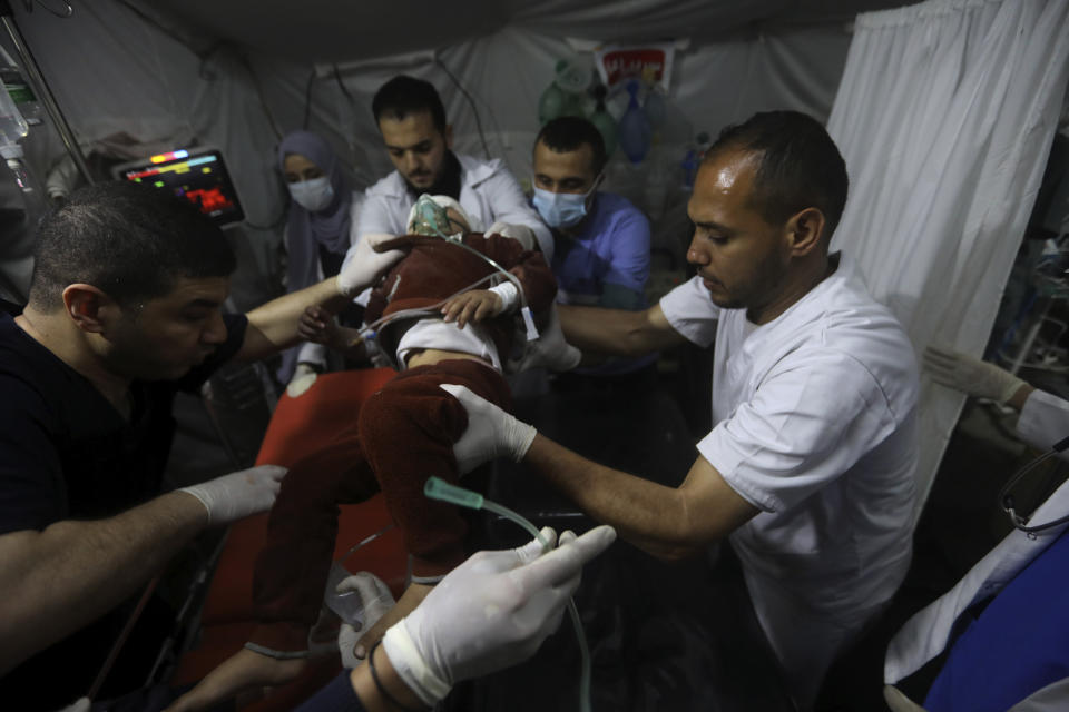 Palestinian medics carry a young wounded in the Israeli bombardment of the Gaza Strip, to the Kuwaiti Hospital in Rafah refugee camp, southern Gaza Strip, early Saturday, April 20, 2024. (AP Photo/Ismael Abu Dayyah)