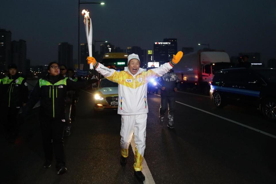 A torchbearer carries the PyeongChang 2018 Winter Olympics torch through Seoul, South Korea (Getty Images)