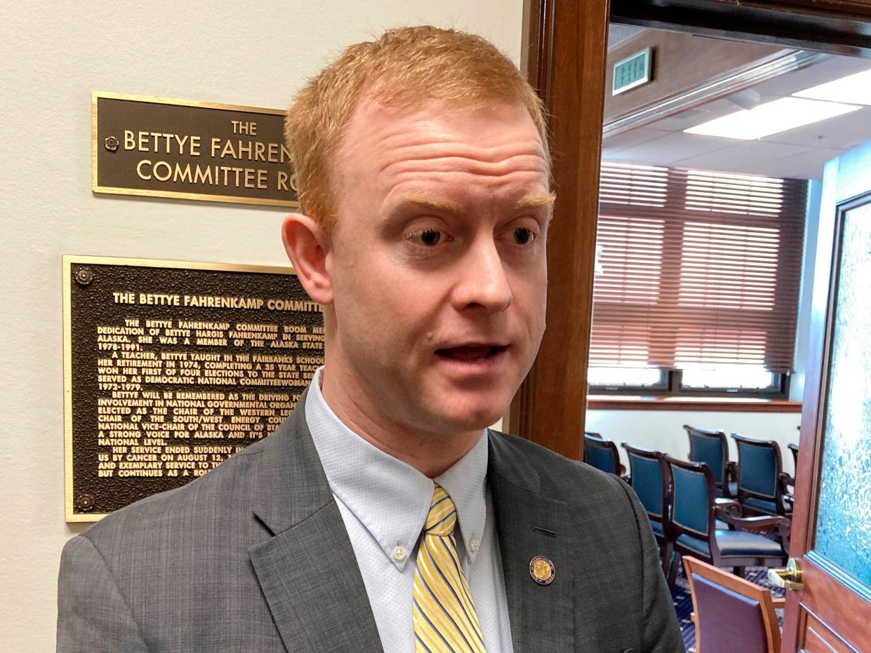 white guy in suit in front of legislative hearing room