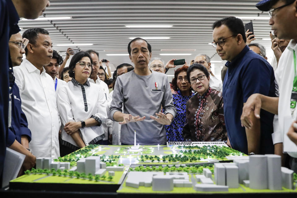 Indonesian President Joko “Jokowi” Widodo, center, inspects a model of Jakarta Mass Rapid Transit network during the inauguration ceremony of the subway line in Jakarta, Indonesia, Sunday, March 24, 2019. The 16-kilometer (10-mile) line system running south from Jakarta's downtown is the first phase of a development that if fully realized will plant a cross-shaped network of stations on the teeming city of 30 million people. (Mast Irham/Pool Photo via AP)