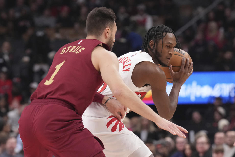 Toronto Raptors' Immanuel Quickley shields the ball from Cleveland Cavaliers' Max Strus (1) during the first half of an NBA basketball game in Toronto, Monday, Jan. 1, 2024. (Chris Young/The Canadian Press via AP)